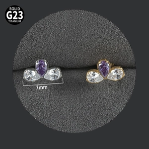 Macro detail of G23 titanium labret studs with purple and white pear zircon clusters