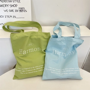 Detail of green and blue canvas tote bags with MFS Harmony typography print
