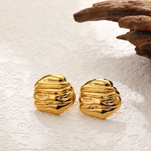 Detailed view of golden irregular pleated earrings with artistic molten metal texture