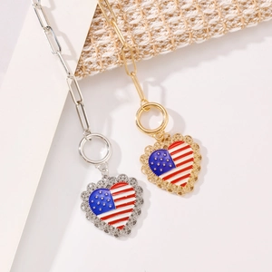 Detail of American flag heart pendants in gold and silver with paperclip chain