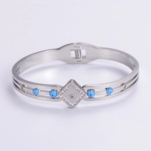 Close-up of silver Evil Eye bangle with blue beads and sparkling crystals detail