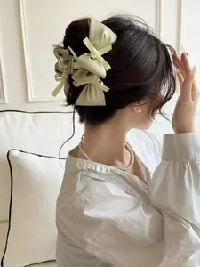 Close-up of a layered silk bow hair claw clip worn on a woman's head for an elegant look