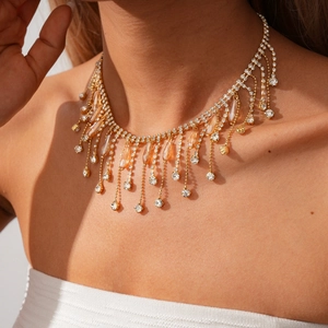 Détail du collier à franges dorées avec cristaux clairs et ambrés porté par un mannequin