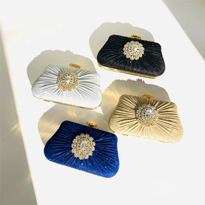 Detailed overhead view of pleated satin evening clutches in black, silver, gold, and blue