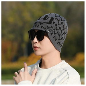 Detail of grey knitted winter hat with visor and letter pattern for outdoor warmth