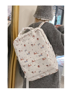 Detailed view of white canvas backpack featuring colorful dachshund and bow prints