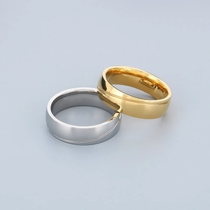 Detail of polished stainless steel rings with minimalist curved groove in gold and silver