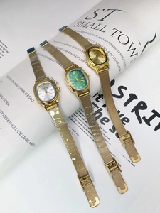 Detailed view of oval vintage quartz watches with colorful dials and gold Milanese straps