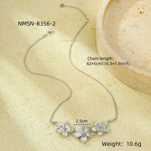 Close-up of silver floral pendant necklace with brushed texture on stone background