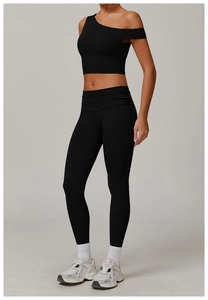 Détail de l'ensemble de yoga noir avec haut asymétrique et leggings de sport taille haute