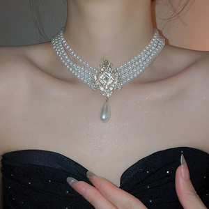 Détail d'un collier de perles multicouche avec pendentif en strass sur un mannequin élégant