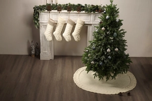 Detail of cable knit Christmas stockings and matching tree skirt in cream white color