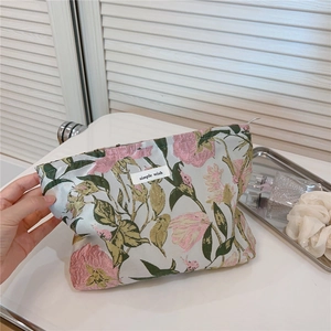 Floral jacquard cosmetic bag featuring simple wish woven label and zipper closure