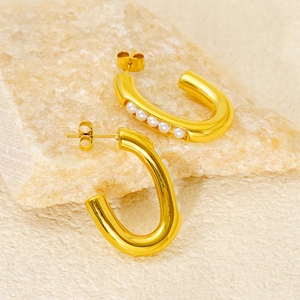 Minimalist U-shaped gold stainless steel earrings with white pearls on natural stone