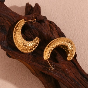 Vue macro détaillée des boucles d'oreilles coque d'arachide plaquées or 18 carats martelées