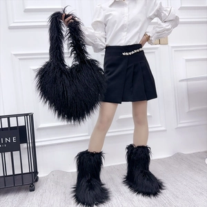 Detail of fluffy black faux fur tote bag and matching ankle boots on fashion model