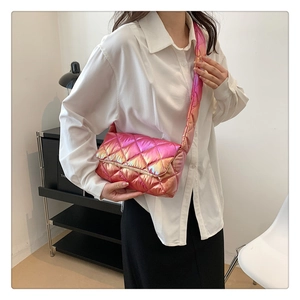 Model wearing a pink quilted crossbody bag with shiny finish and diamond pattern