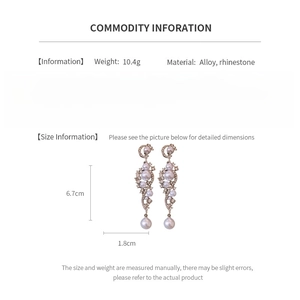 Detail view of pearl tassel earrings showing size specifications and rhinestone moon design
