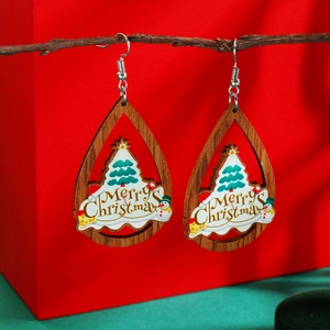 Macro detail of wooden teardrop Christmas earrings with Merry Christmas print and tree