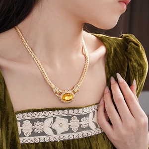 Vintage gold snake chain necklace with an oval yellow crystal pendant and diamond halo