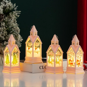Detail of four Christmas LED lanterns with warm lights and festive painted patterns