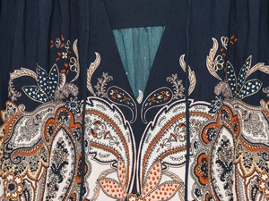 Détail du col en V avec liens et imprimé paisley sur cette blouse bleu marine