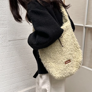 Close-up of beige fleece tote bag featuring a brown leather logo and soft texture