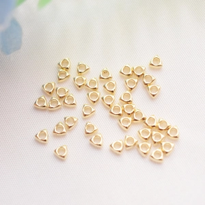 14k gold-filled hollow triangle spacer beads for DIY jewelry making on white fabric