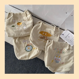 Gros plan de sacs cabas en velours côtelé avec broderies cartoon et texture douce