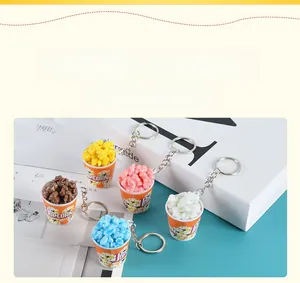 Detailed view of 5-piece set popcorn bucket keychains in various colors on a magazine
