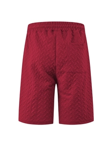Detailed view of red jacquard fabric texture and rear pocket on men's beach shorts