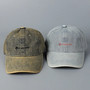 Detailed embroidery on washed denim baseball caps in tan and light blue vintage styles