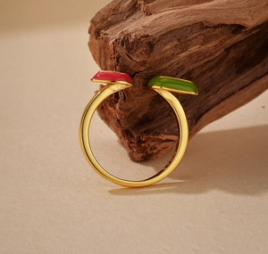 Detail of S925 sterling silver open ring with pink and green stones on gold band