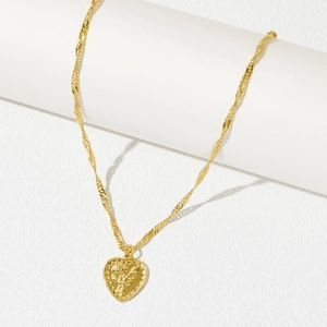 Detail of gold twisted chain necklace with a heart pendant featuring a rose flower relief