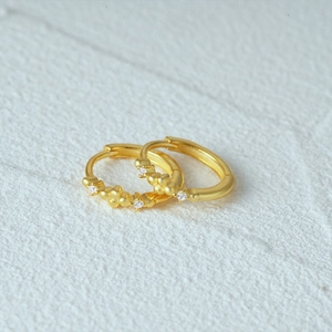 Macro shot of gold S925 sterling silver geometric hoop earrings with cubic zirconia