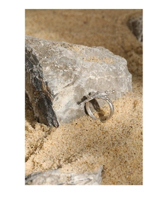 Macro detail of silver S925 sterling silver ring with organic fluid texture on rock