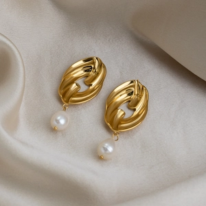 Detail showing 18K gold plated pearl earrings on champagne silk background