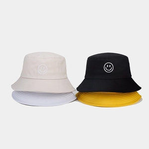 Détail de la broderie smiley sur plusieurs chapeaux bob en coton de différentes couleurs