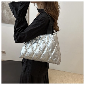 Model showing side view of the silver quilted tote bag for daily commute and style