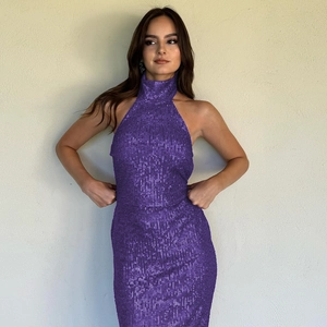 Close-up of elegant purple sequin evening gown with high neck halter and slim fit design