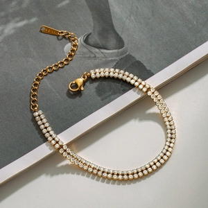 Detail of gold double-row tennis bracelet with S.STEEL hallmark and lobster clasp