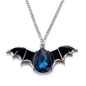Detailed shot of a silver bat pendant with black enamel wings and a blue pear-shaped gem