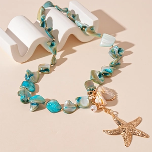 Detailed shot of ocean theme necklace with golden starfish charm and sea shell beads