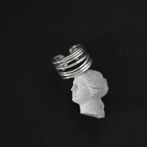 Macro detail of the silver multi-layer open ring on a white artistic sculpture