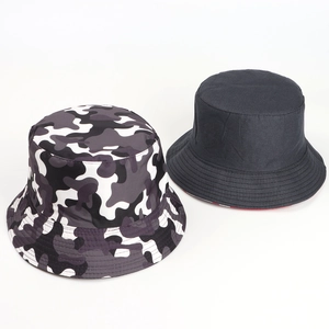 Détail d'un chapeau bob réversible avec motif camouflage et noir uni avec bord surpiqué