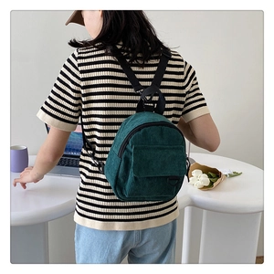Detailed shot of a green corduroy backpack showing soft texture and nylon straps