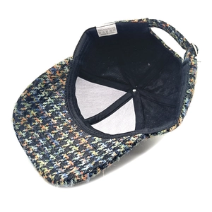 Detail of tweed baseball cap interior showing black lining and adjustable metal buckle