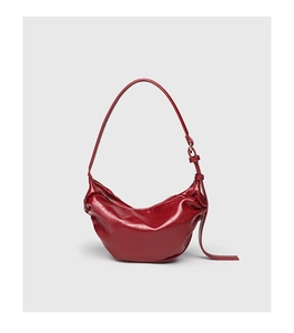 Detail of the deep red hobo bag showing the oil-waxed texture and soft leather pleats