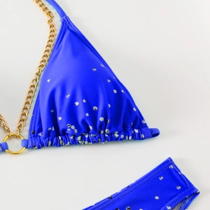 Detail of royal blue bikini top with spotted print and golden chain strap hardware