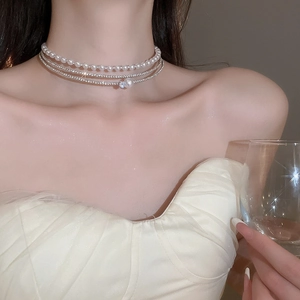 Macro shot of multilayer choker featuring sparkling rhinestones and elegant white pearls